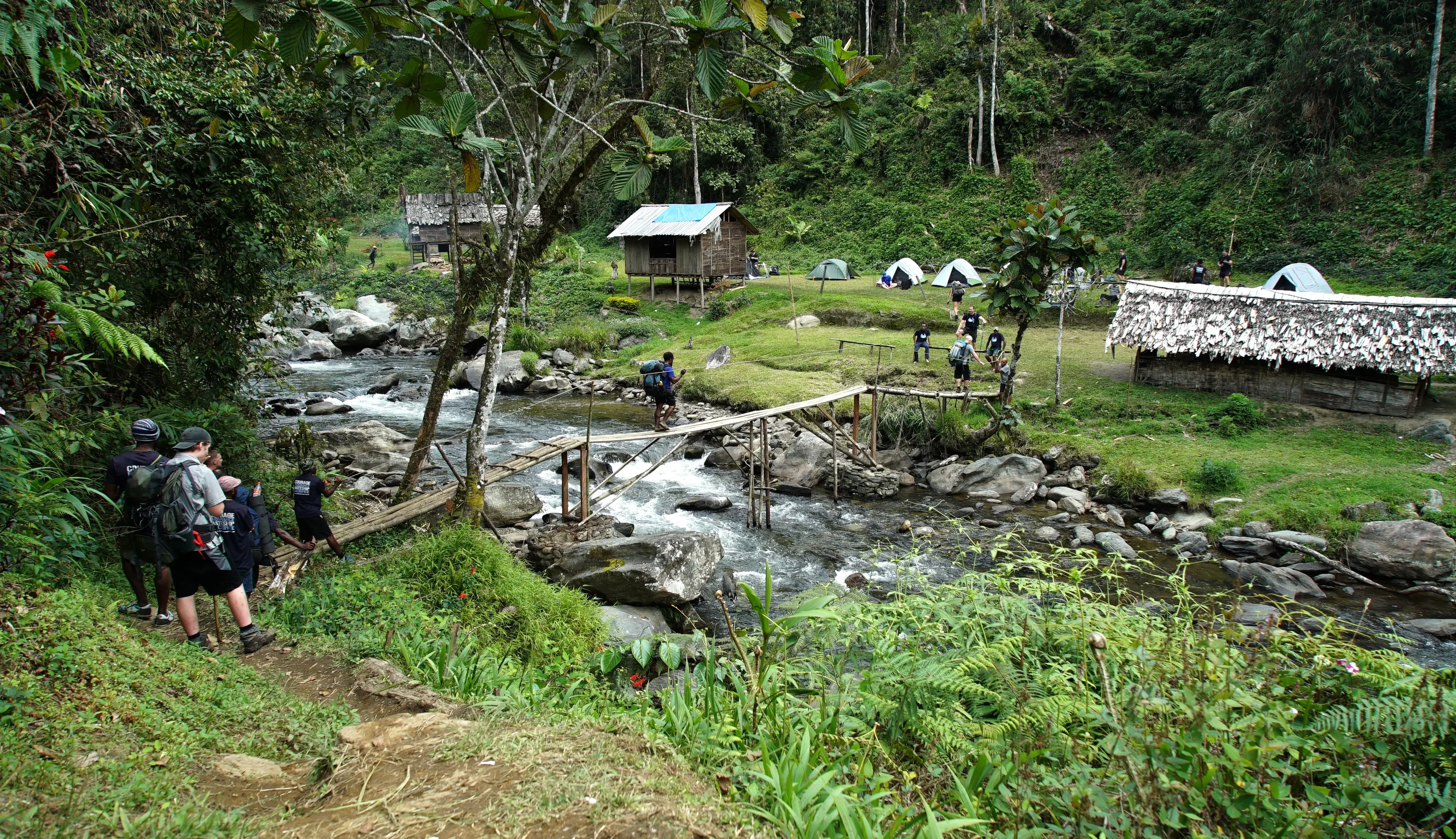 Kokoda Courage trekkers approaching a river crossing near a village campsite